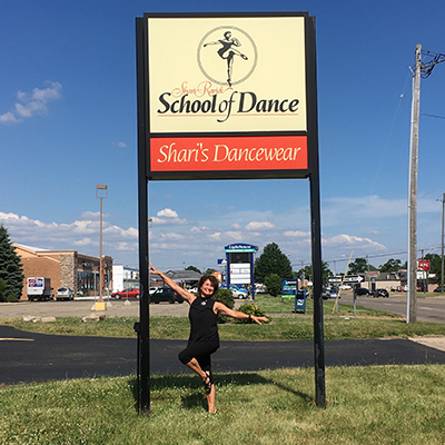 shari rarick in front of a sign